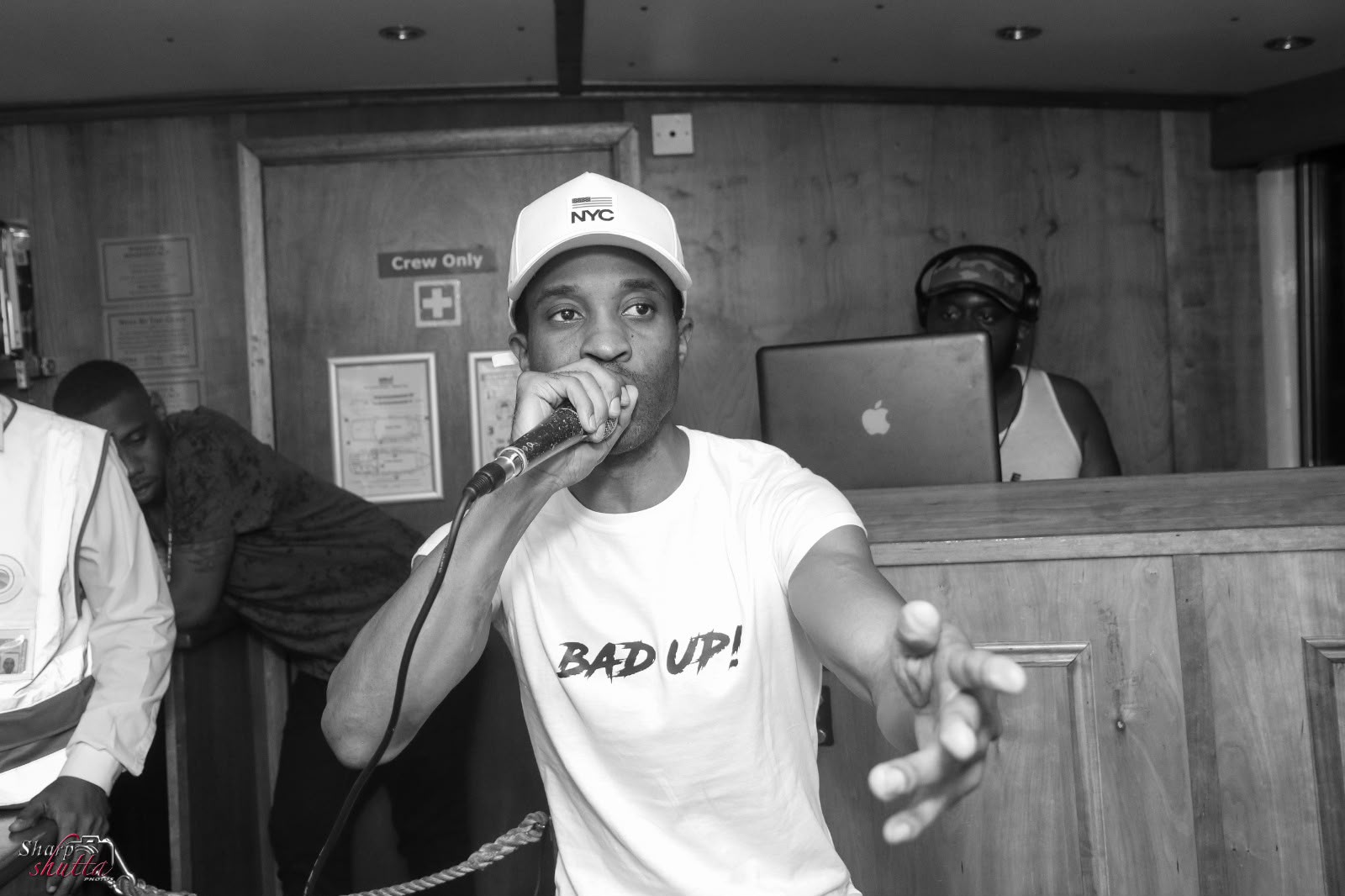 Black and white shot of Raver performing in a Bad Up! tee at a live set